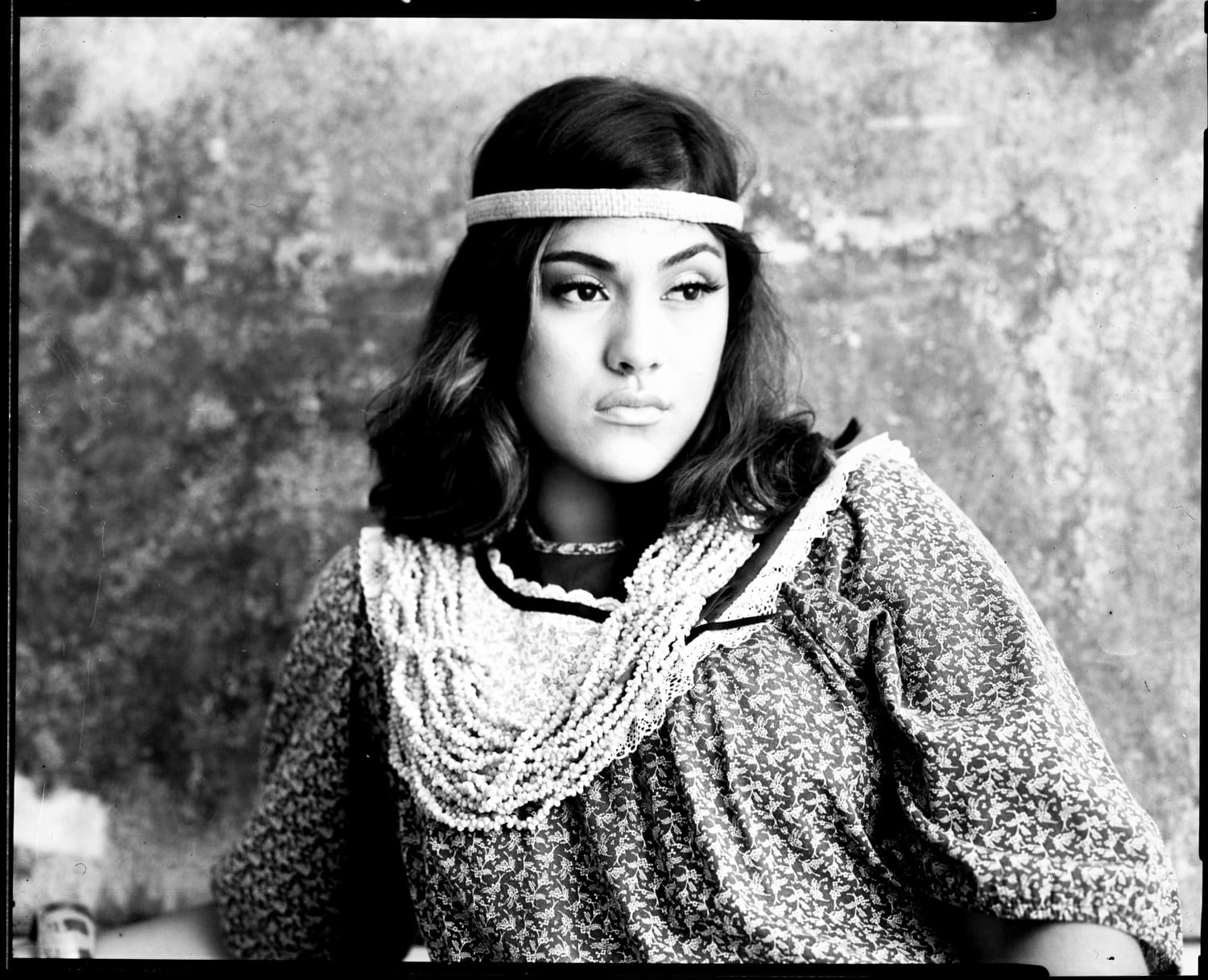 Black and white film portrait of a woman in a beaded headband and lace collar