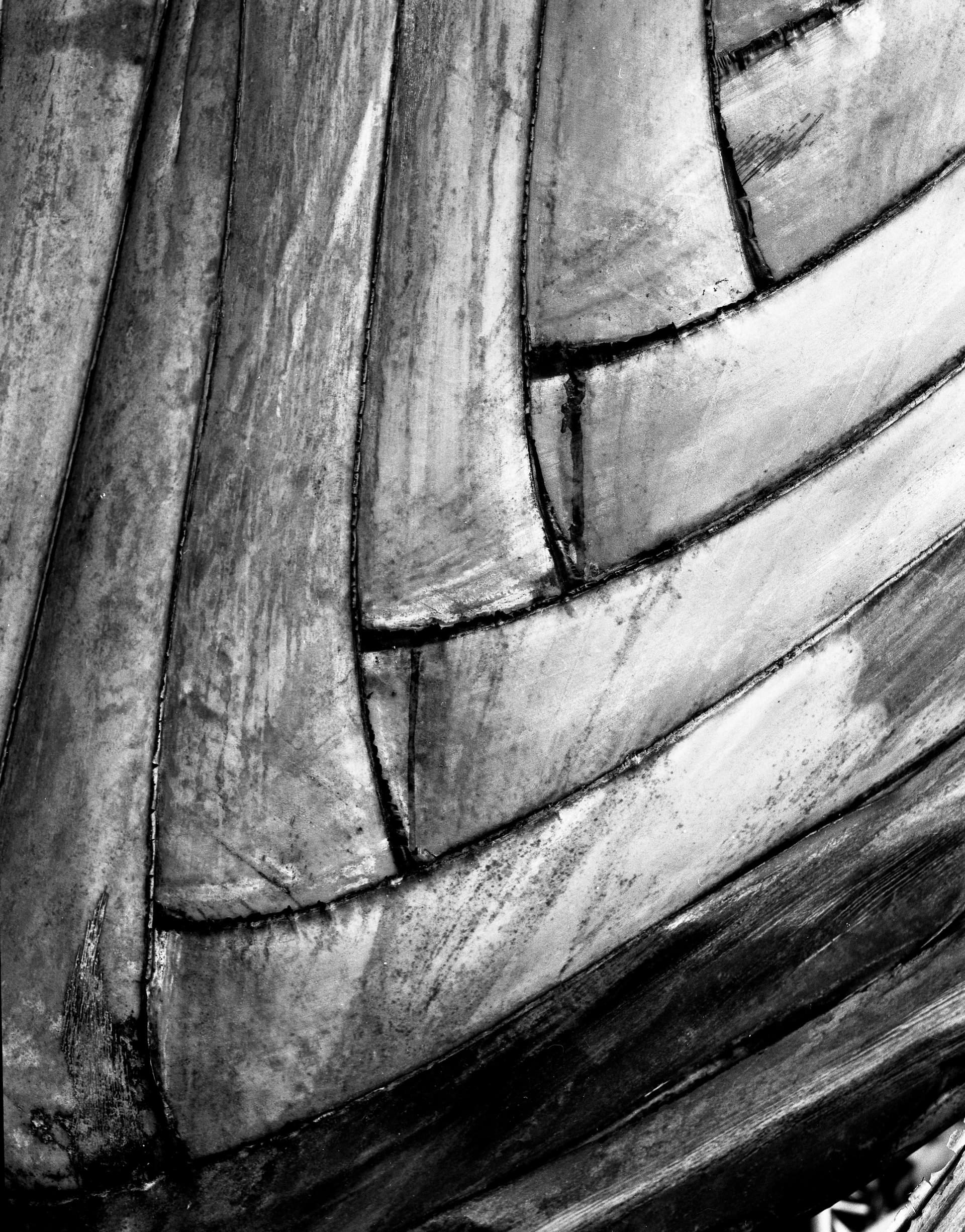 Black and white photograph of curved wooden planks
