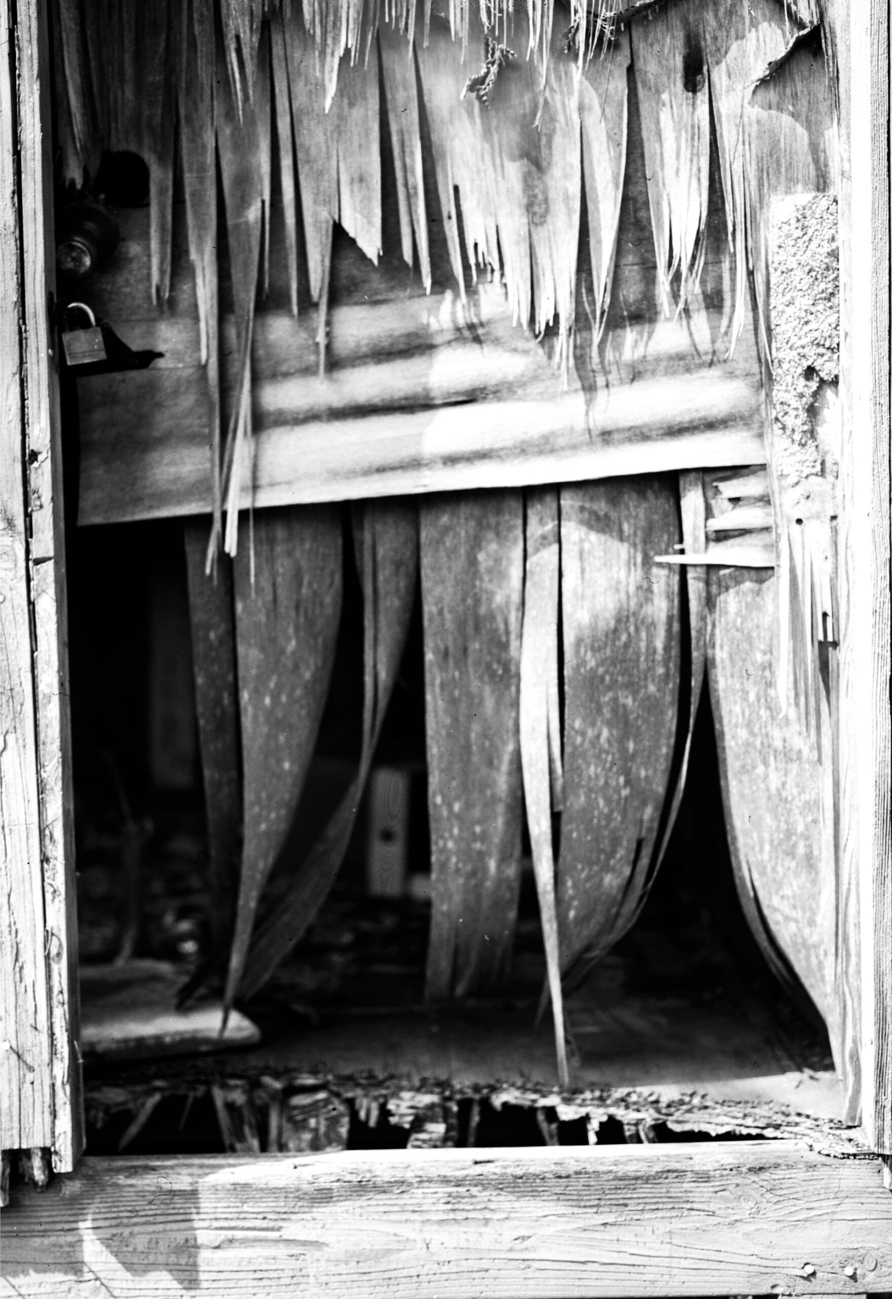 Black and white photograph of a weathered wooden door