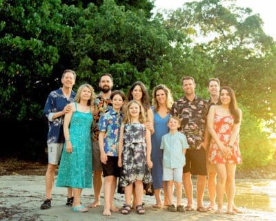 Family portrait on Kona beach at sunset by a photographer in Hawaii, featuring a family in soft golden hour light with a stunning beach backdrop.