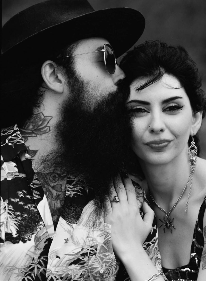 Man kissing his partner's cheek in a black and white portrait