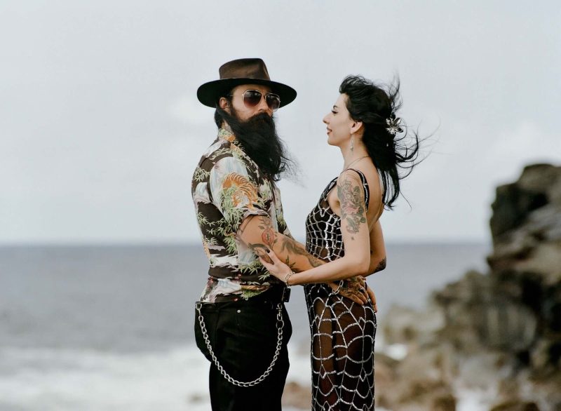 Couple facing each other on a windy sea cliff