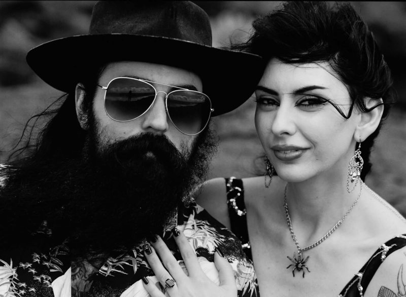Black and white close-up of a couple in sunglasses and hats