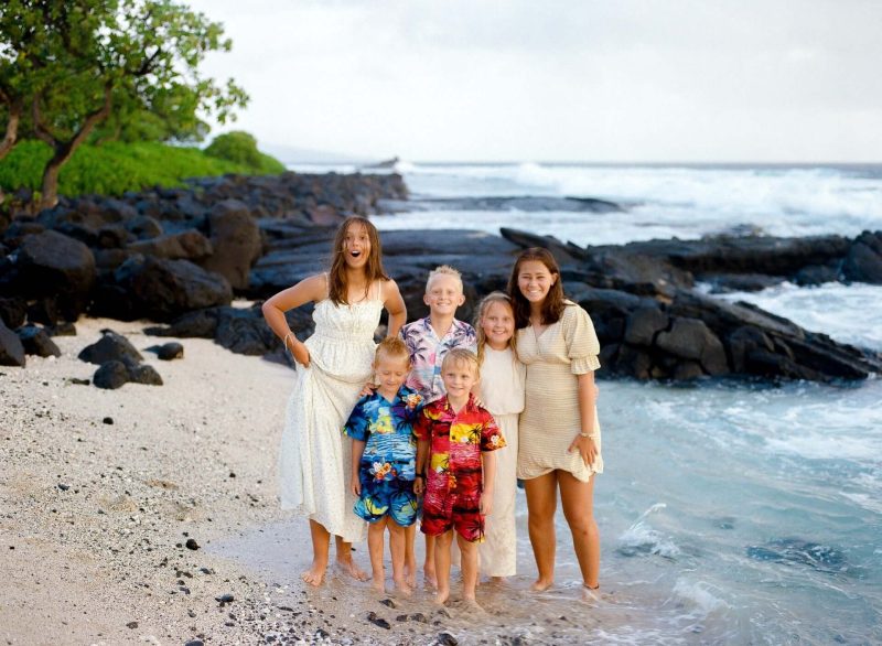 Mother and grandmother with children on a lava rock beach