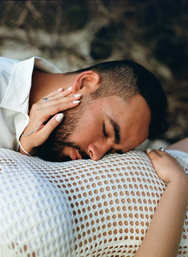 Man resting his head on his partner's baby bump