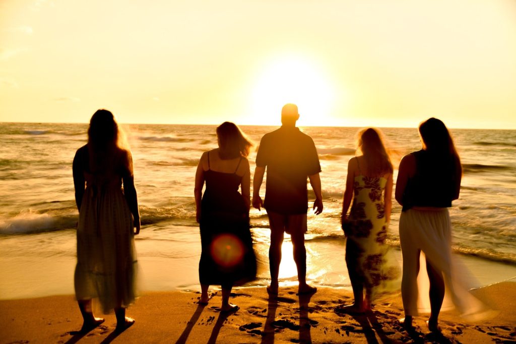 Family silhouetted against the setting sun on a Hawaii beach, sunset photo without flash